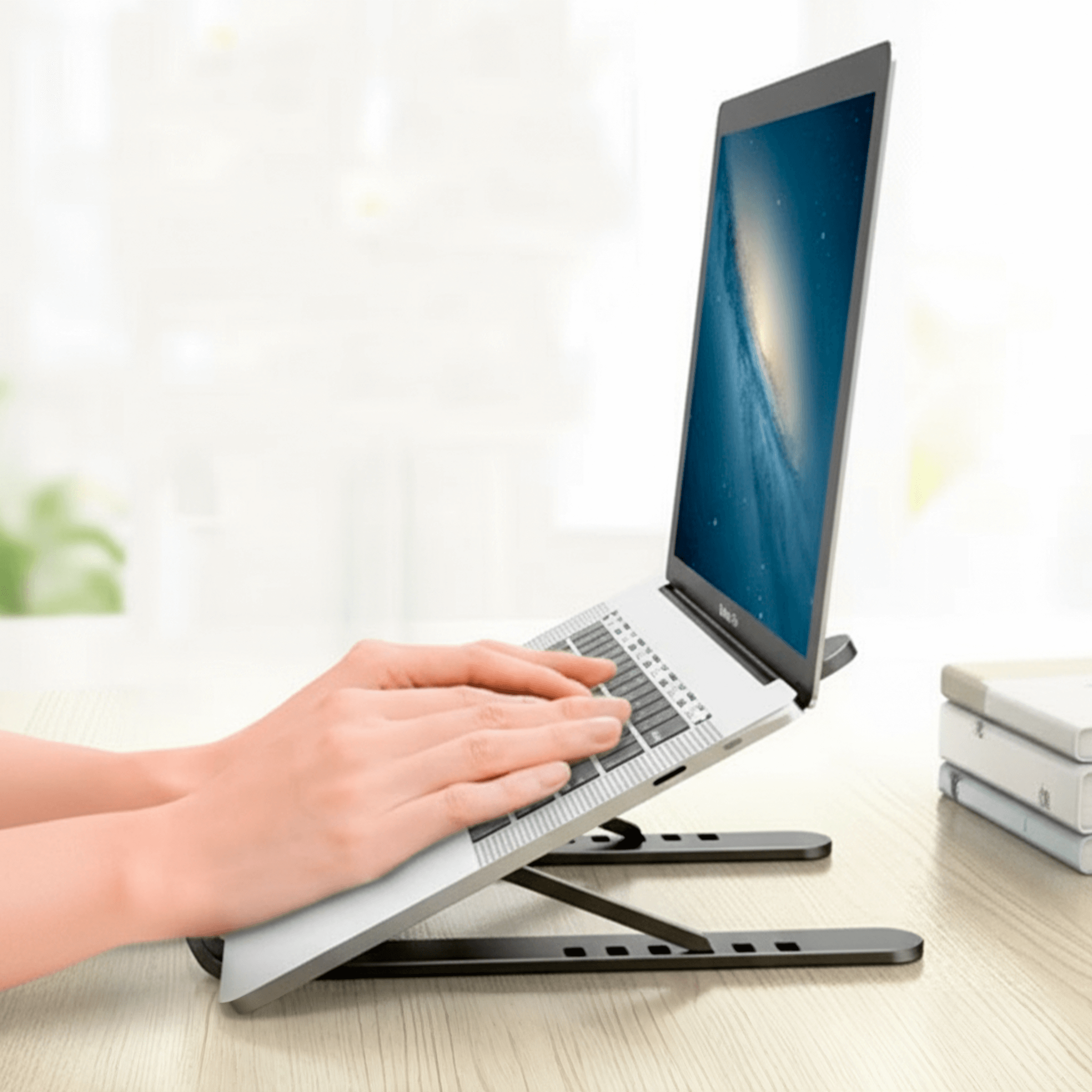 Pessoa utilizando notebook apoiado na base ajustável ergonômica para maior conforto