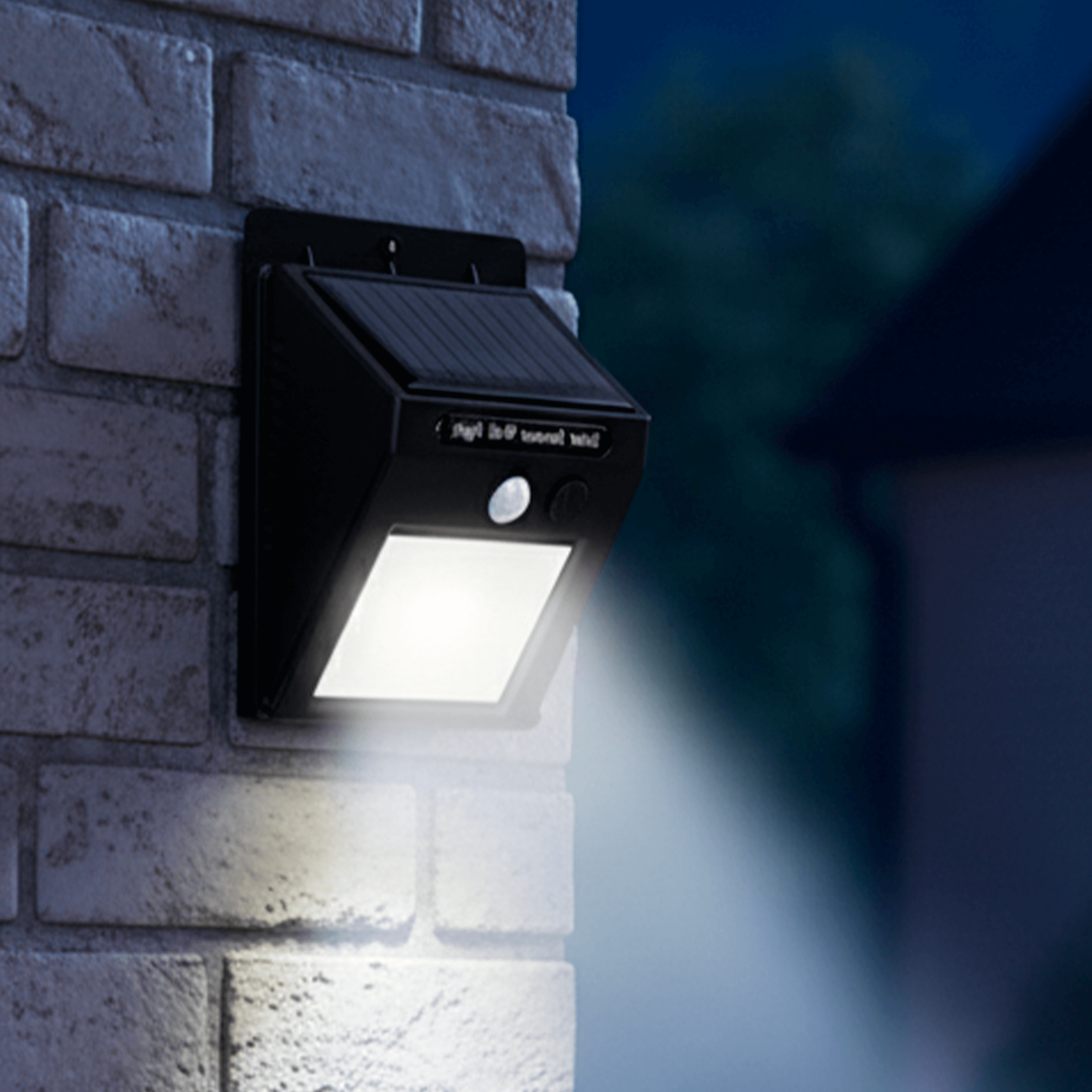 Luminária solar com sensor de presença iluminando parede externa durante a noite, ideal para segurança e economia de energia